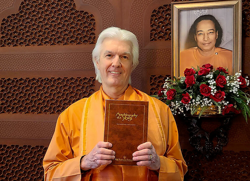 Brother Chidananda holding new Autobiography of a Yogi Deluxe Edition